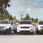 The full lineup of white Jeeps facing the camera with palm trees in back