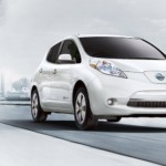 An overexposed image of a white 2017 Nissan Leaf driving away from a city