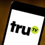 Black smartphone with a white screen showing the "truTV" logo in black lettering