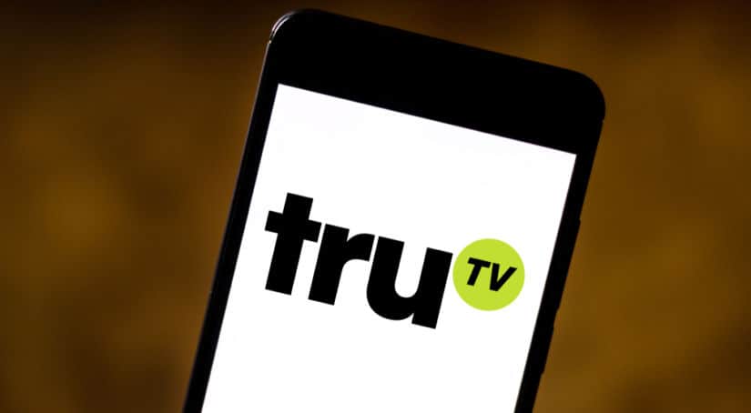 Black smartphone with a white screen showing the "truTV" logo in black lettering