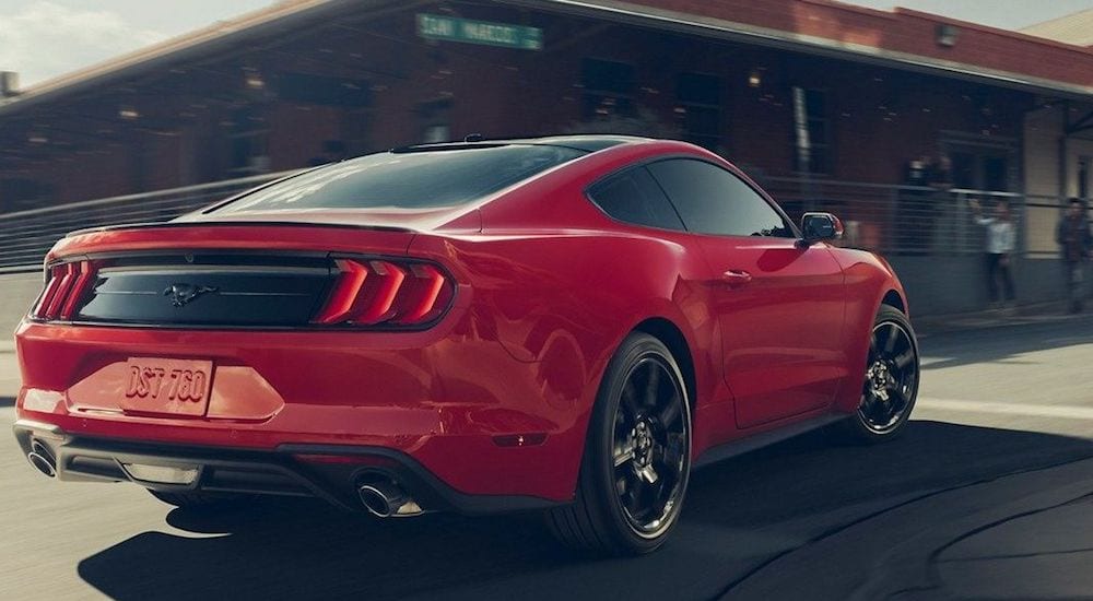 A red 2019 Ford Mustang takes a corner on a city street