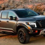 A silver Nissan Titan with desert rocks