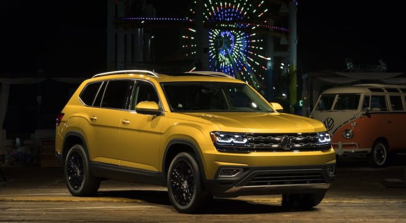 Yellow Volkswagen Atlas in front of a carnival at night