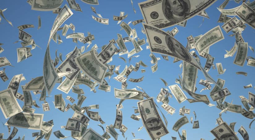 Tons of one-hundred dollar bills falling from a blue sky