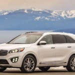 A white 2018 Kia Sorento in front of a lake and mountains