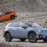 Blue and orange Subaru Crosstreks in a gravel pit