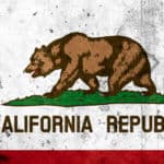 Brown bear standing on grass with a red star above it and the words "California Republic" below it