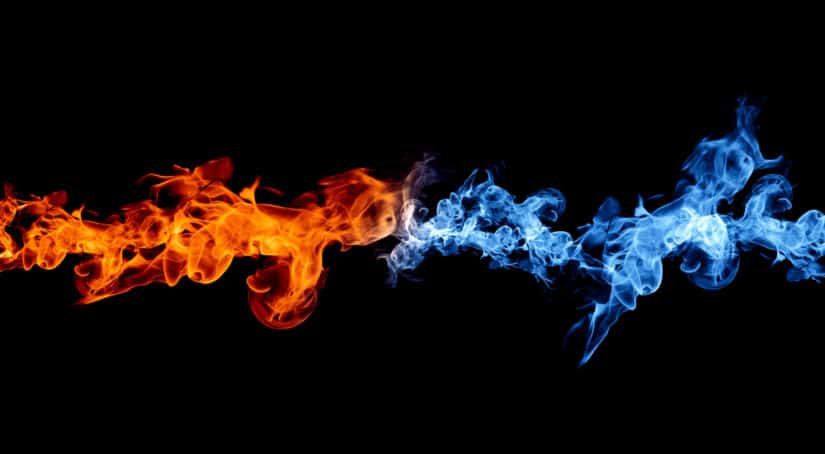 Black background with orange flames coming from the left and blue flames coming from the right