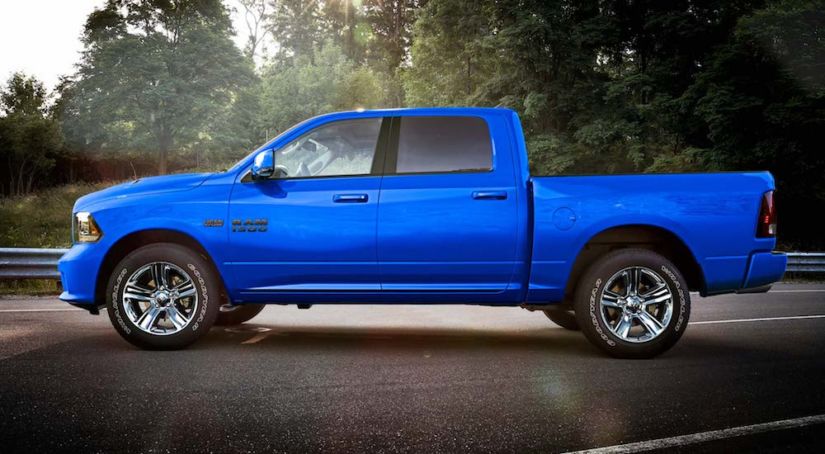 Backlit blue 2019 Ram 1500 with trees in background