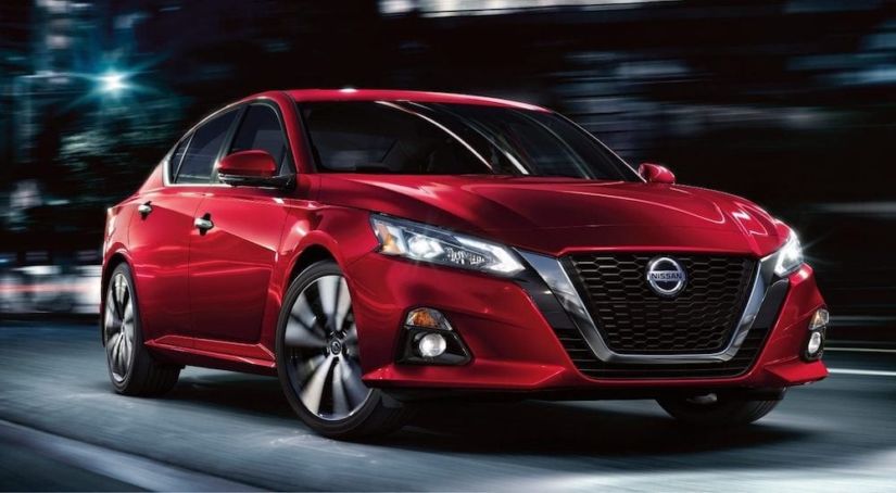 Dark Red 2019 Nissan Altima driving in city at night