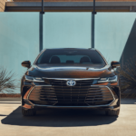 Front of an amber 2019 Toyota Avalon in front of glass wall