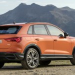 Orange 2019 Audi Q3 in front of mountains