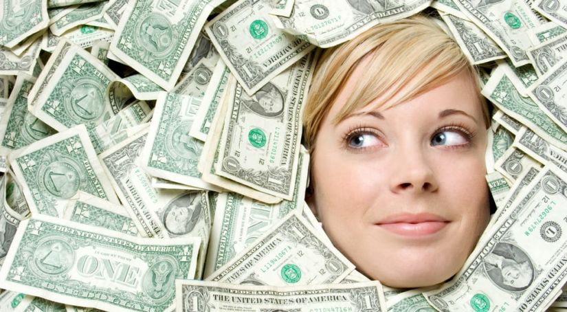 Closeup of a blonde woman's face surrounded by money