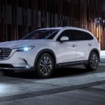 White Mazda SUV on a dark city street