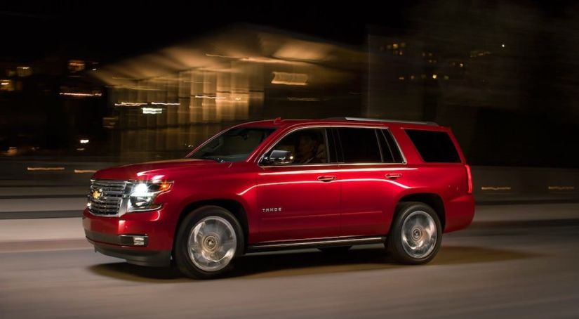 Red 2019 Chevy Tahoe driving at night
