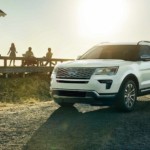 White 2019 Ford Explorer at beach with family on beach house deck in back