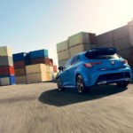 Blue 2019 Toyota Corolla driving between shipping containers