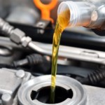 A bottle pouring oil into a car engine