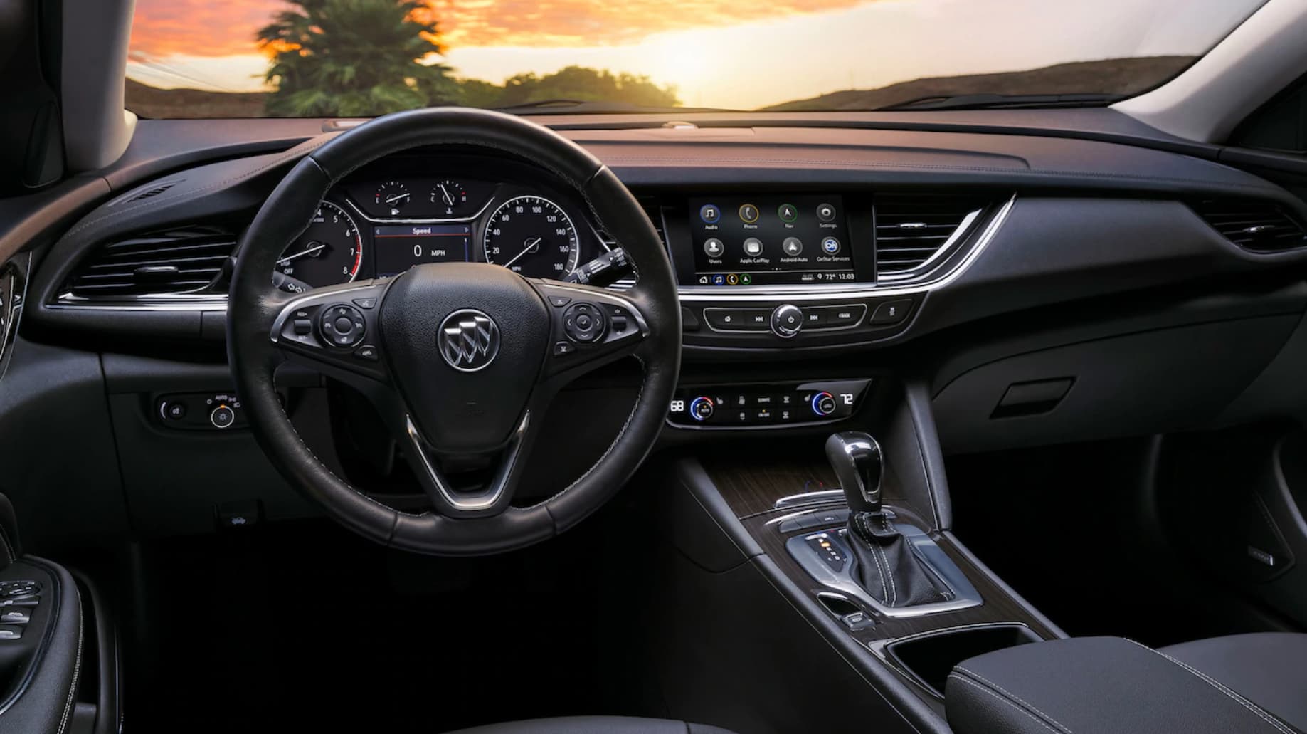 Black leather interior of 2019 Buick Regal Tourx dashboard at sunset