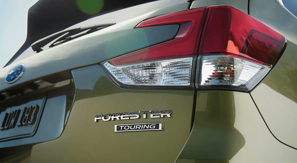 Closeup of passenger rear badging of green 2019 Subaru Forester Touring
