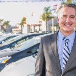 Car salesman standing outside a dealership