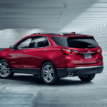 A red 2019 Chevy Equinox under a modern bridge or parking garage