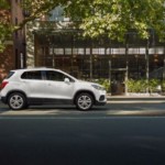 A white 2019 Chevy Trax on a tree-lined city street