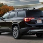 A black 2019 GMC Acadia All Terrain in front of a glass building