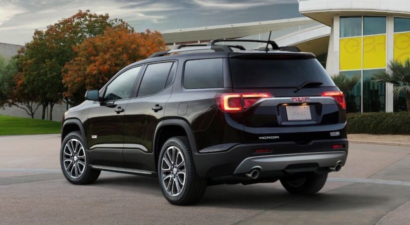 A black 2019 GMC Acadia All Terrain in front of a glass building