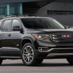 A black 2019 GMC Acadia All Terrain in front of a building