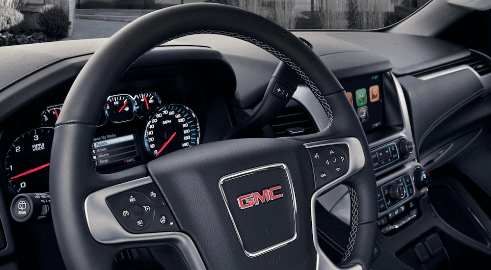A closeup of a 2019 GMC Yukon XL steering wheel and dashboard