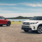 White and red 2019 Toyota Highlanders at the beach