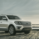 A white 2019 Ford Expedition parked by the water on a dock