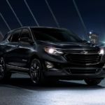 A black Midnight Edition 2020 Chevy Equinox, which wins when comparing the 2020 Chevy Equinox vs 2020 Toyota RAV4, is on a bridge at night.