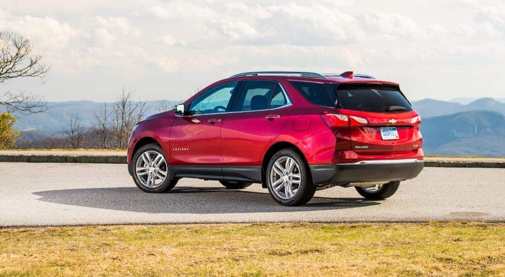 A red 2020 Chevy Equinox is parked with a view of distant hills.