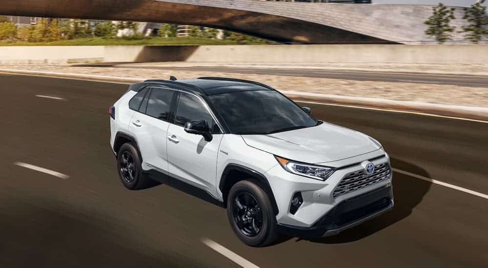 A white 2020 Toyota RAV4 is driving on a highway.