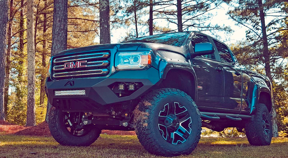 A lifted gray GMC in the forest