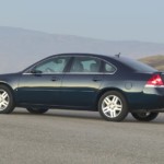 A used 2010 Chevrolet Impala driving on a mountain road