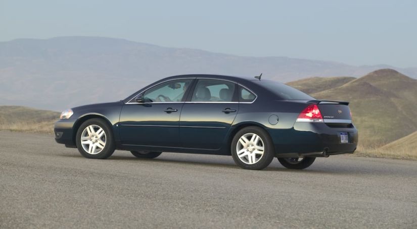 A used 2010 Chevrolet Impala driving on a mountain road
