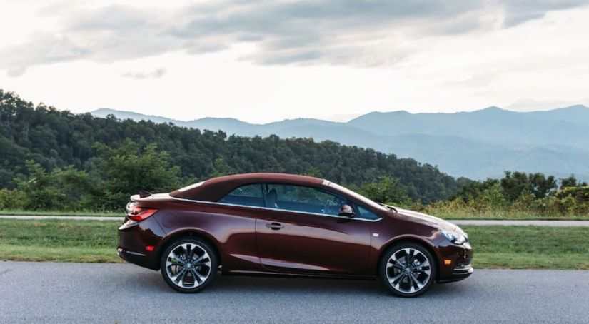 A dark red 2019 Buick Cascada with mountains in the back