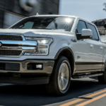 A white 2019 Ford F150 towing a boat and pulling away with the win of 2019 Ford F-150 vs 2019 Ram 1500
