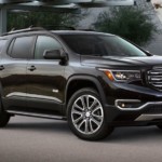 A black 2019 GMC Acadia All Terrain in front of an upscale home