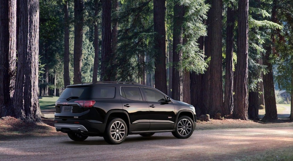 A black2019 GMC Acadia All Terrain in the forest