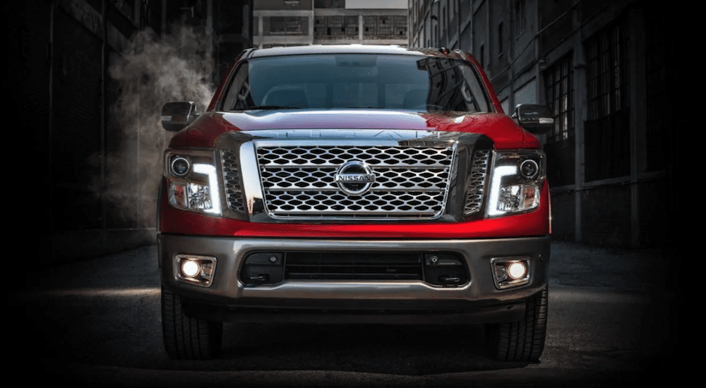 A closeup of a red 2019 Nissan Titan in an alley