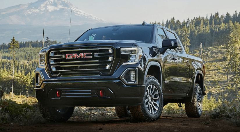 A black 2019 GMC Sierra 1500 in front of an epic snow capped mountian