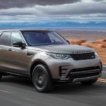 A silver 2019 Land Rover Discovery travels an empty desert highway