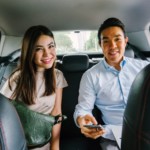 A man and woman sitting in the backseat of a car