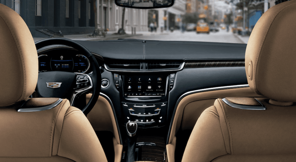 The interior of the 2019 Cadillac XTS from the backseat overlooking a busy city street