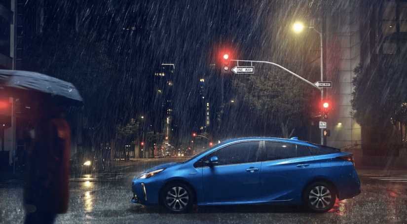 A blue 2019 Toyota Prius caught in the rain