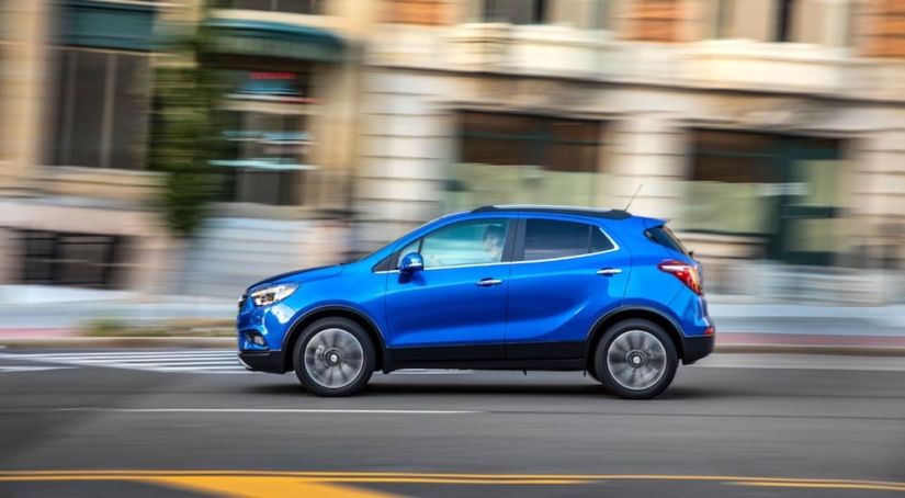 A blue 2019 Buick Encore driving off with a win for 2019 Buick Encore vs 2019 Mazda CX-3